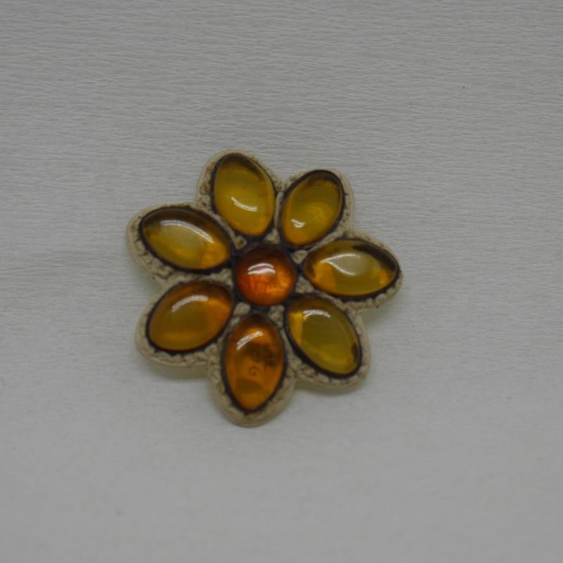 alt=\"Broche de ámbar, cuero y plata en forma de flor\"